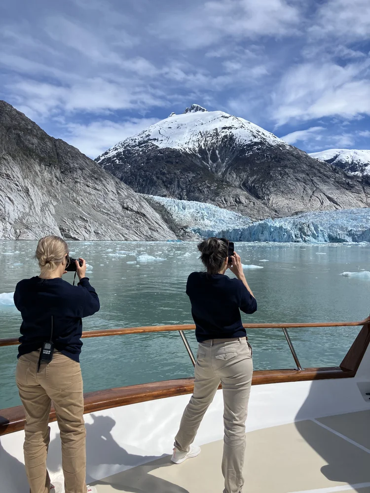Guests on the bow deck of Motor Yacht Oceana photographing glaciers