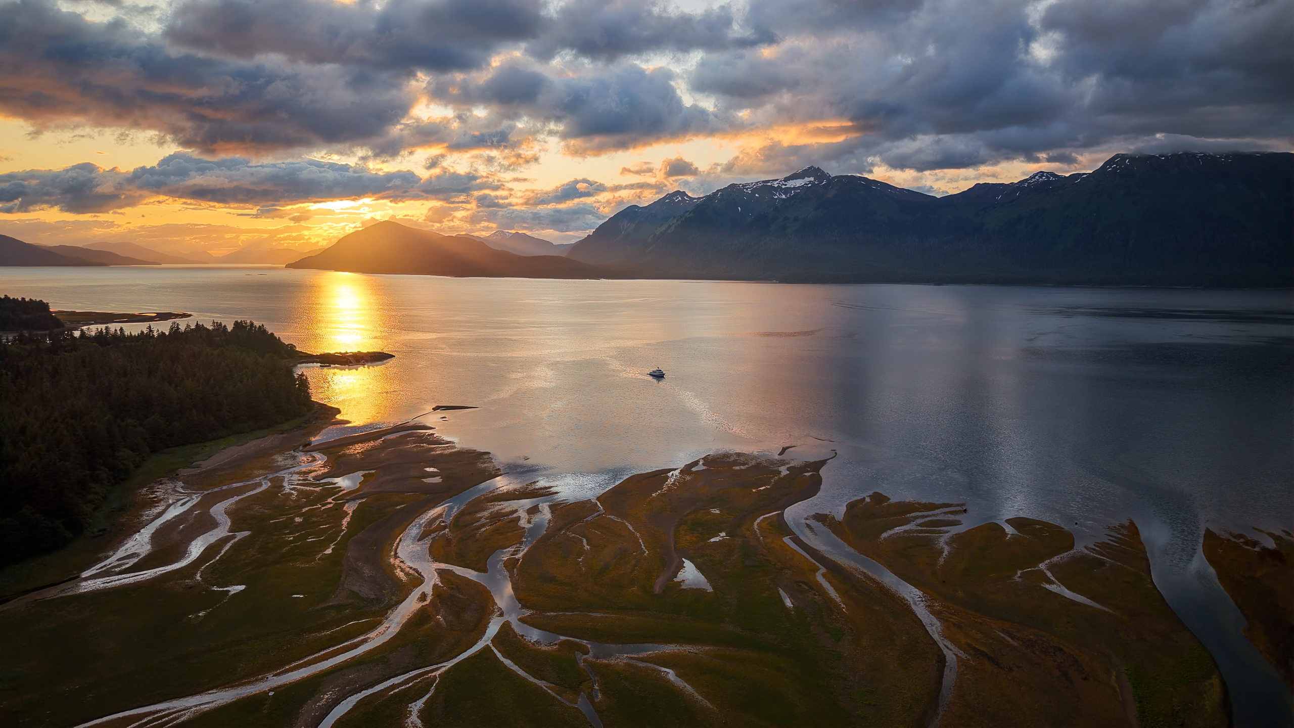 Motor Yacht Oceana at sunset in a Southeast Alaska fjord, mountains and golden light