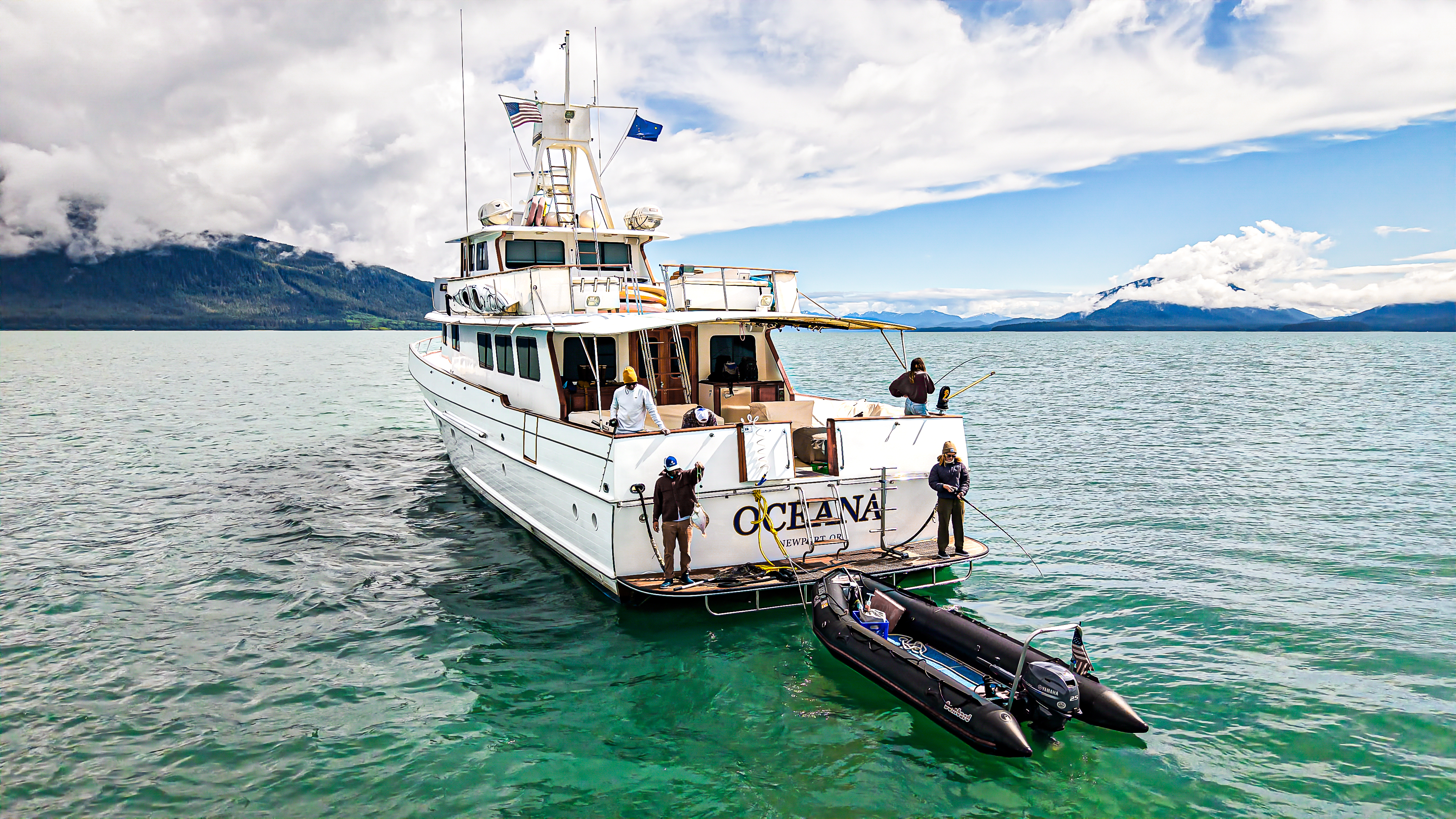 Motor Yacht Oceana at anchor with tender alongside in turquoise Alaska waters